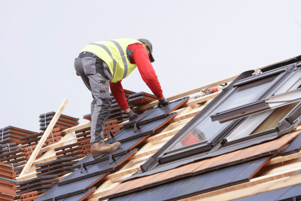 Banbury Roofers working on a tiled roof with new roof windows